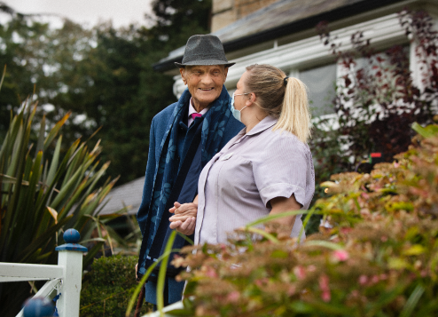 A carer holding a mans hand